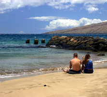 Couple sitting on beach in Maui